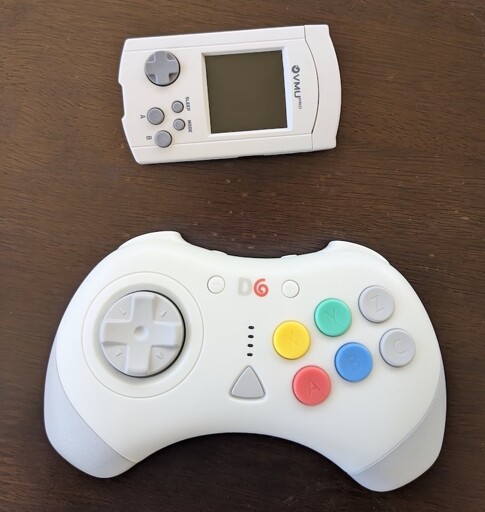A six-button d-pad controller, matching the aesthetics of a Dreamcast controller. And an upgraded Dreamcast VMU, the 8BitMods VMUPro.