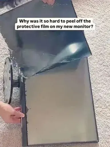 "Why was it so hard to peel off the protective film on my new monitor?" Picture of a monitor with the (necessary) black sheet ripped of.