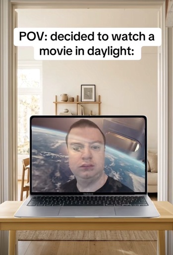 Photo of a laptop computer with a strong glare on the screen and a reflection of the user with the caption “pov: decided to watch a movie in daylight”